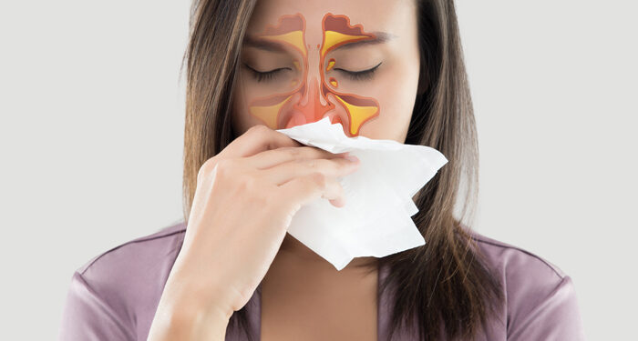 Asian women in satin robes feeling unwell and sinus against gray background. Dust allergies. Flu. People caught cold and allergy.